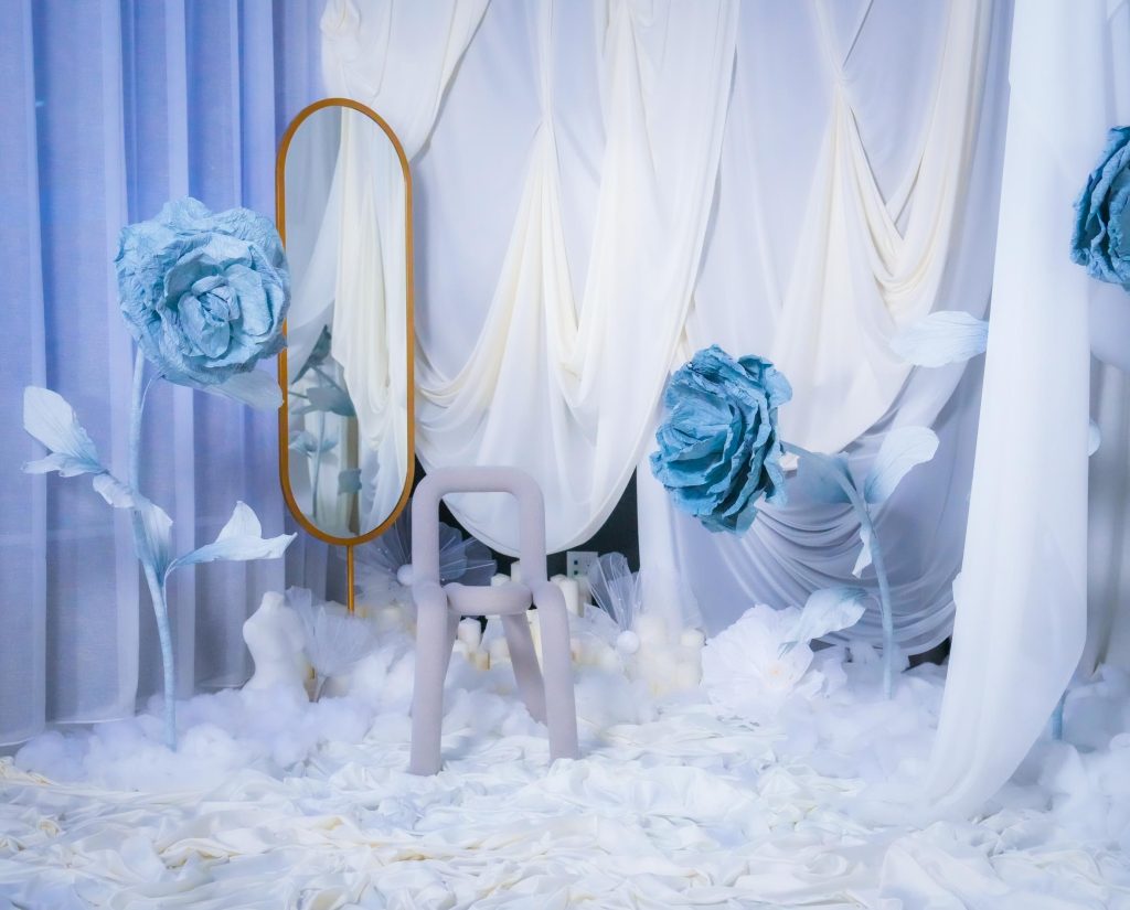 rystal Garden set at Hadaki Studios, featuring a soft white draped backdrop, giant blue flowers, a modern chair, and a gold mirror, ideal for photoshoots in Toronto.