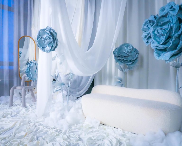 featuring a white draped backdrop, giant blue flowers, a plush sofa, and a gold mirror, ideal for photoshoots in Toronto.