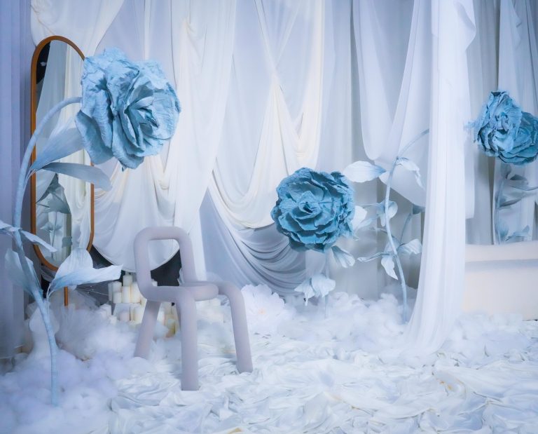 Crystal Garden set at Hadaki Studios, showcasing giant blue flowers, a modern chair, a gold mirror, and elegant white drapery, ideal for photoshoots in Toronto.