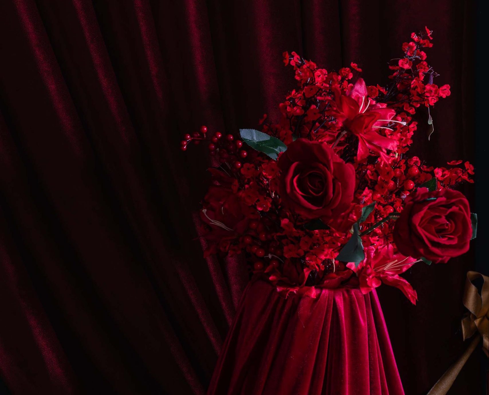 Red Muse floral arrangement at Hadaki Studios featuring deep red roses, holiday berries, and velvet drapery—luxurious detail from the holiday photoshoot set in Toronto.