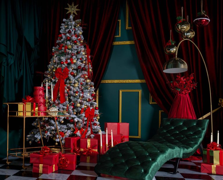 Full Red Muse holiday set at Hadaki Studios featuring a decorated Christmas tree, emerald chaise lounge, red gifts, vintage gold accents, velvet drapery, and candles—perfect for holiday photoshoots in Toronto.